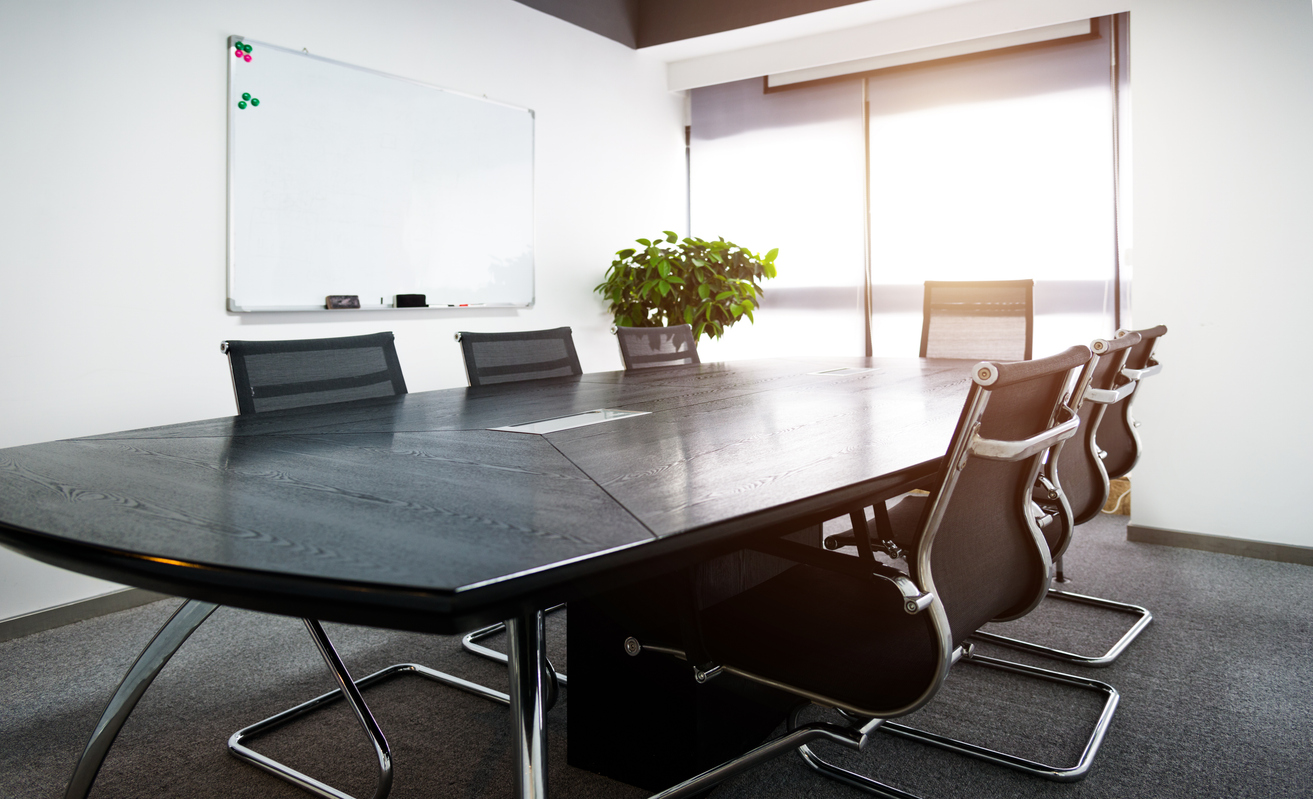Daylit conference room with a long meeting table and seating